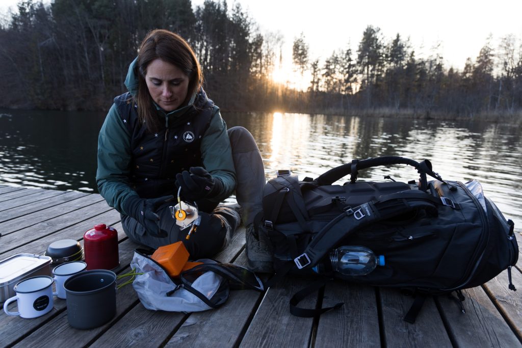 Ambassador Pia Steen with camping gear at a lake in Bavaria, Shinn 80 DuraDiamond camera pack