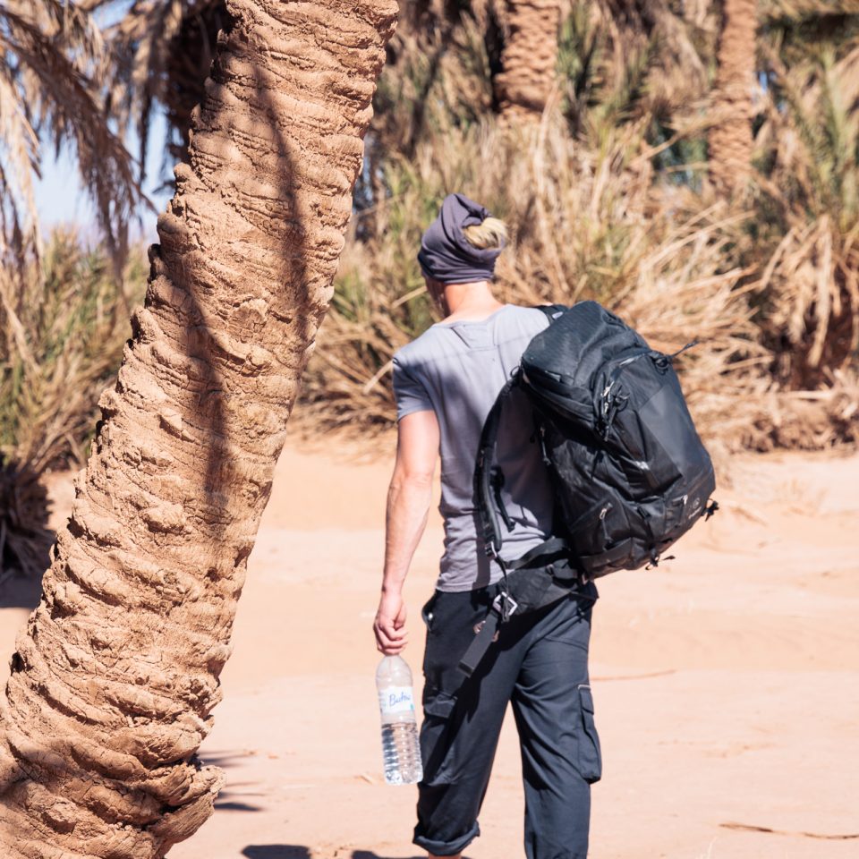 f-stop Tilopa 50 liter DuraDiamond® camera backpack in the Anthracite Black color option on a beach
