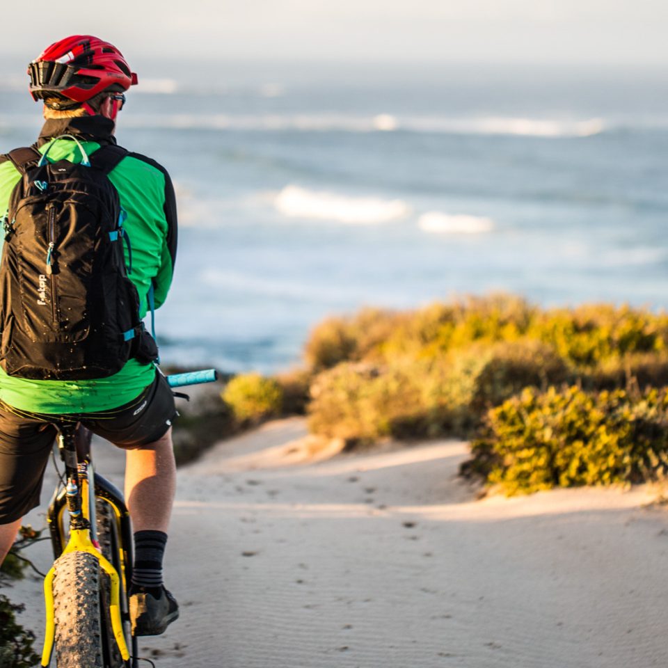 Craig Kolesky with Guru UL on bike at the beach