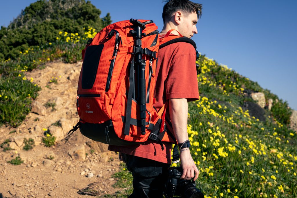 f-stop Tilopa 50 liter DuraDiamond® camera backpack in the Magma Red color option being worn with a landscape in the background